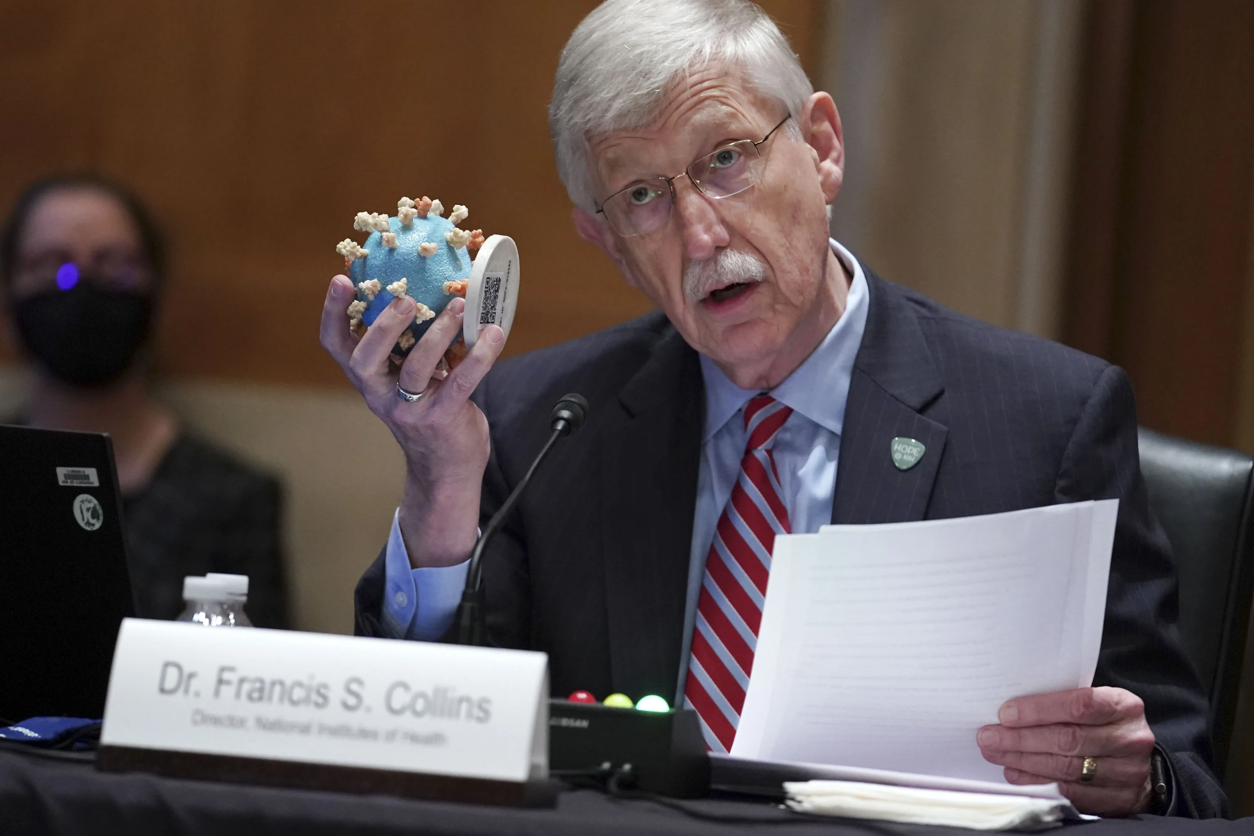 Francis Collins holds up a model of Covid-19 during a Senate Appropriations Subcommittee hearing in Washington, on May 26, 2021.