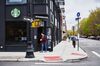 A customer wearing a protective mask orders outside of a Starbucks coffee shop in the Brooklyn borough of New York, U.S., on Monday, April 27, 2020. Starbucks Corp. is scheduled to release earnings figures on April 28.