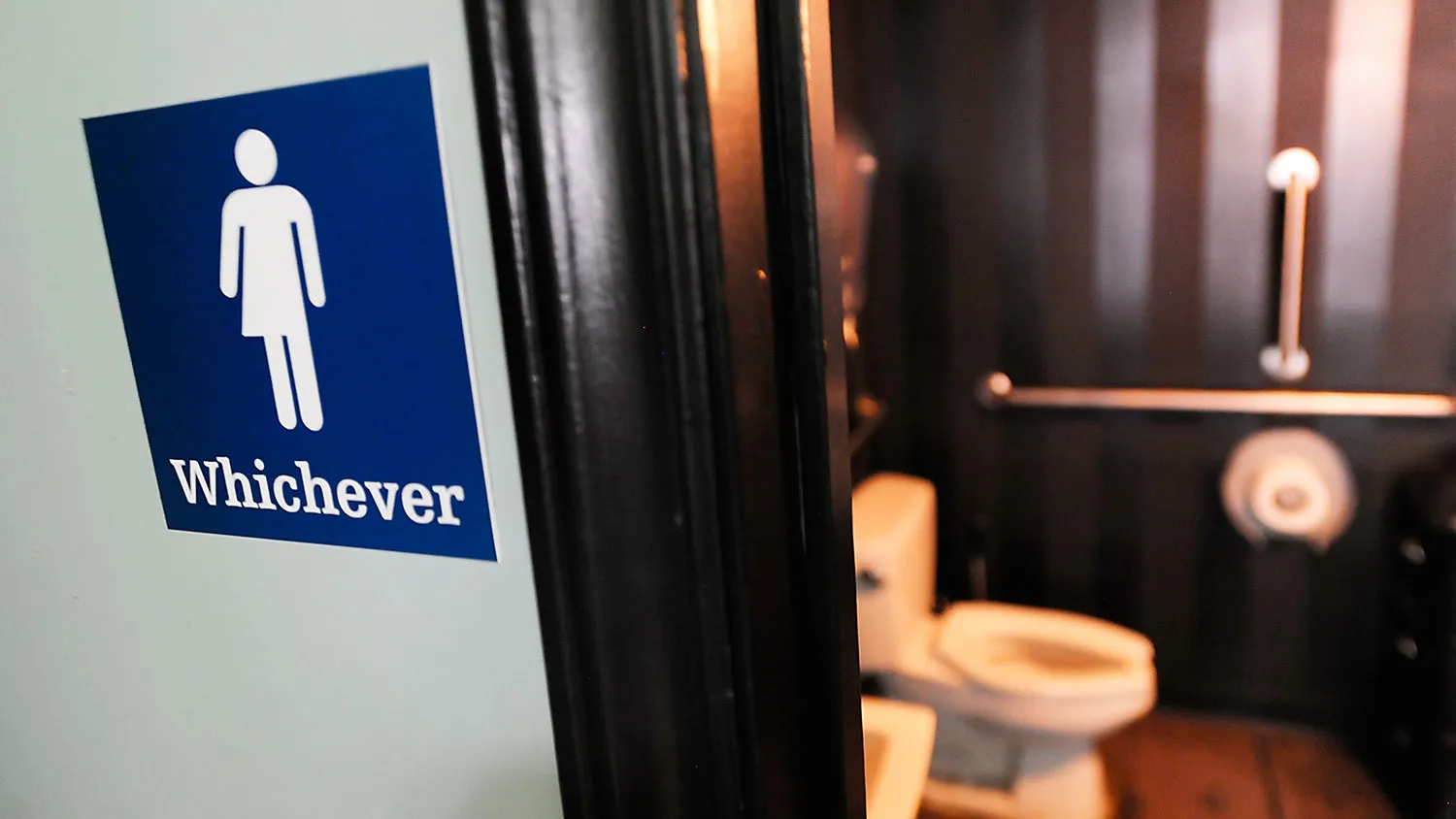 A gender-neutral sign is posted outside a bathrooms at Oval Park Grill on May 11, 2016, in Durham, North Carolina.
