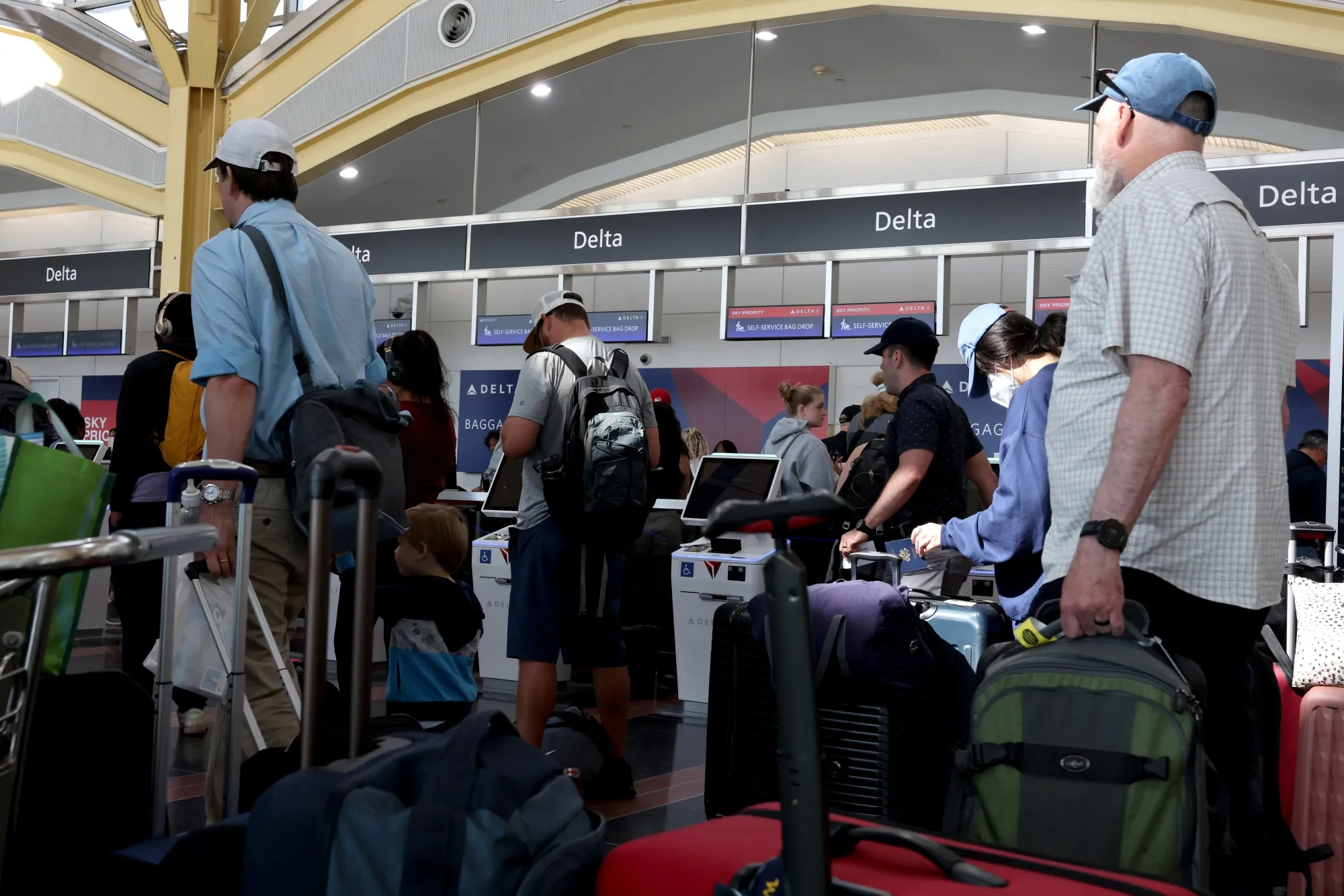 Travelers wait in line at a Delta Airlines counter at Ronald Reagan National Airport in Arlington, Virginia on July 19.