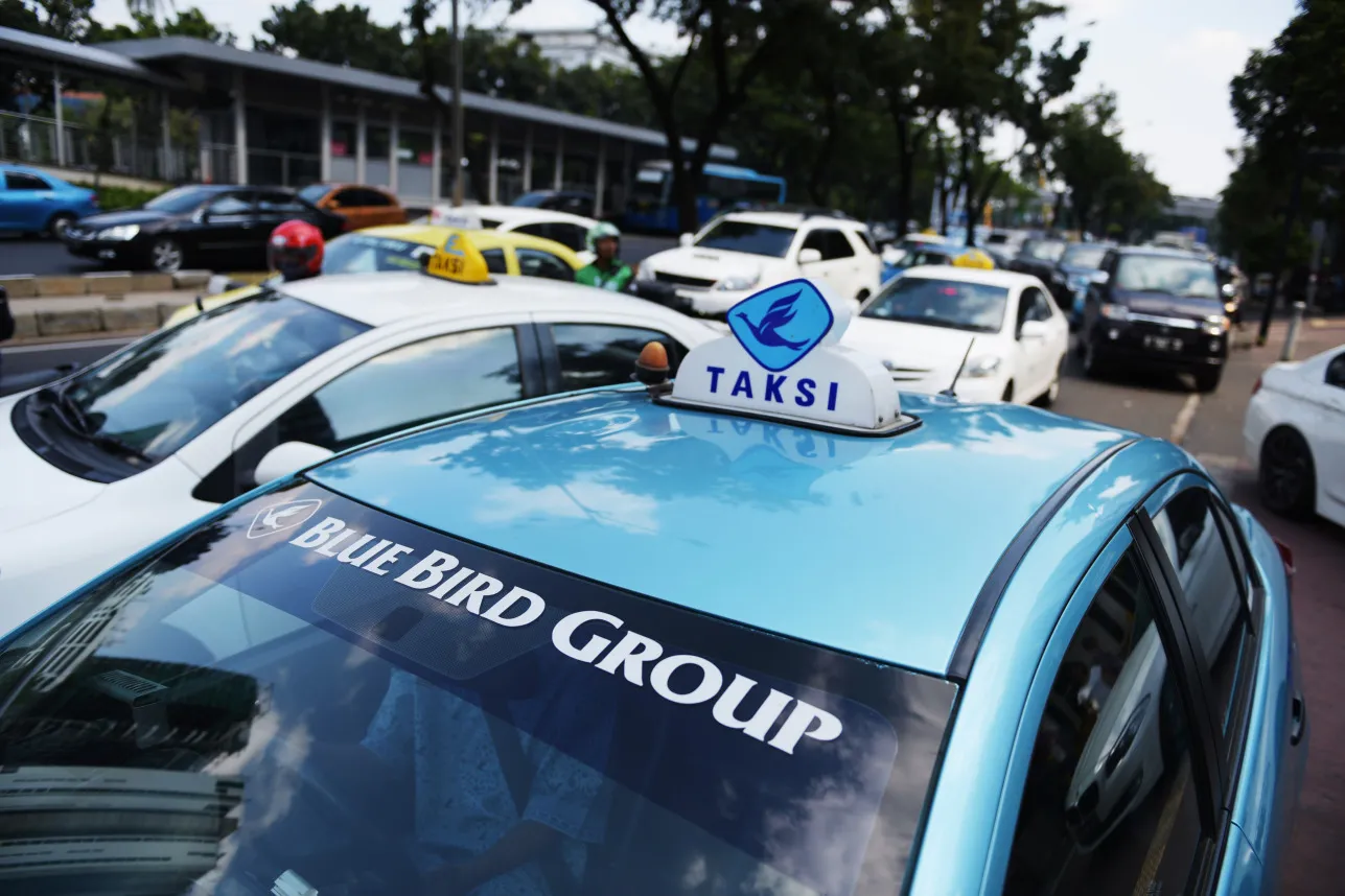 A Blue Bird Group taxi sits in traffic in Jakarta, Indonesia, on Friday, June 26, 2015. Blue Bird, Indonesia's largest taxi operator, operates about 28,900 vehicles, about three times its closest rival PT Express Transindo Utama.