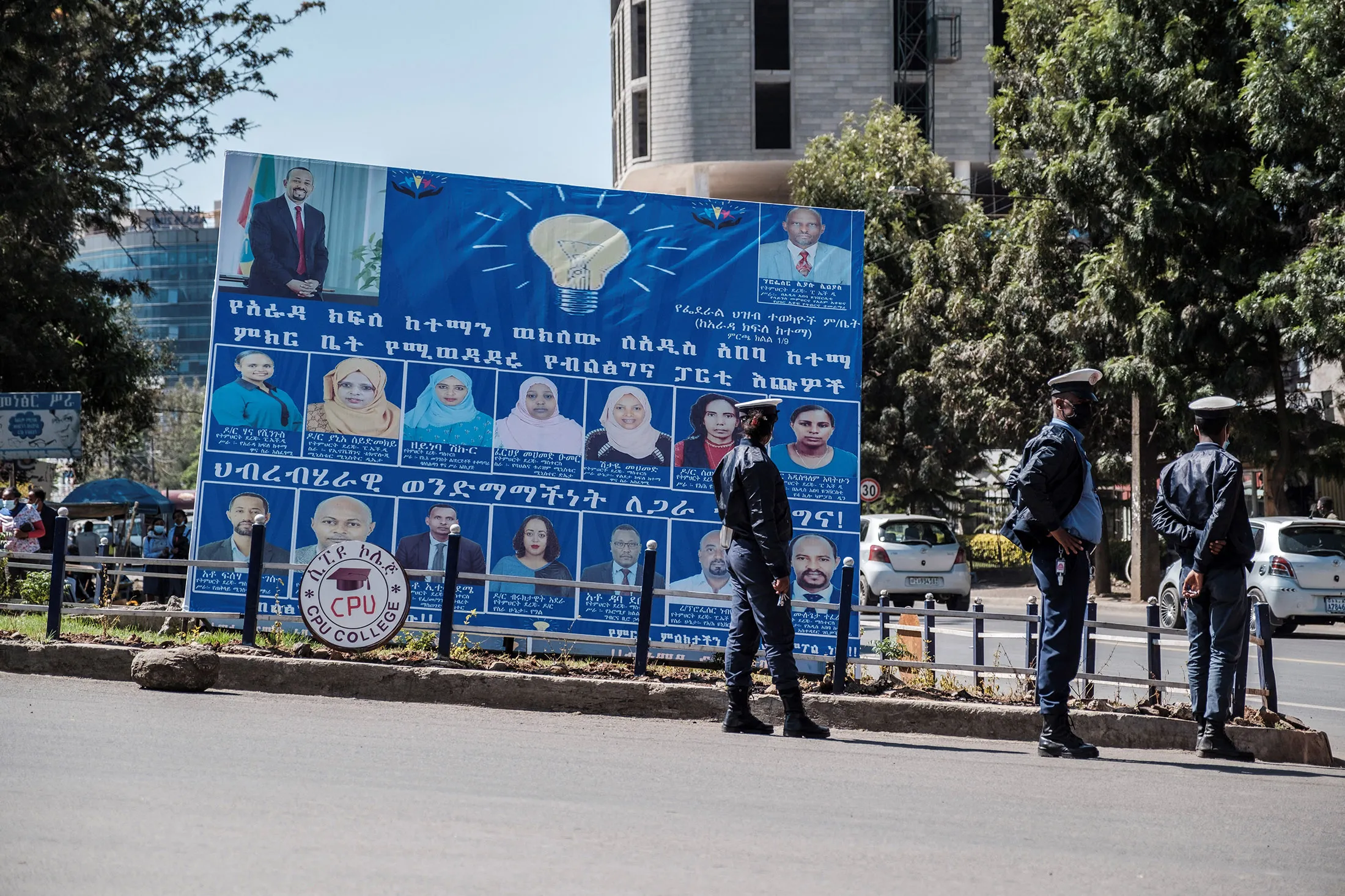 Police officers stand in front of a billboard of the political party of Ethiopian Prime Minister Abiy Ahmed, The Prosperity Party, during the electoral campaign for the general elections&nbsp;in Addis Ababa, Ethiopia, on April 20.