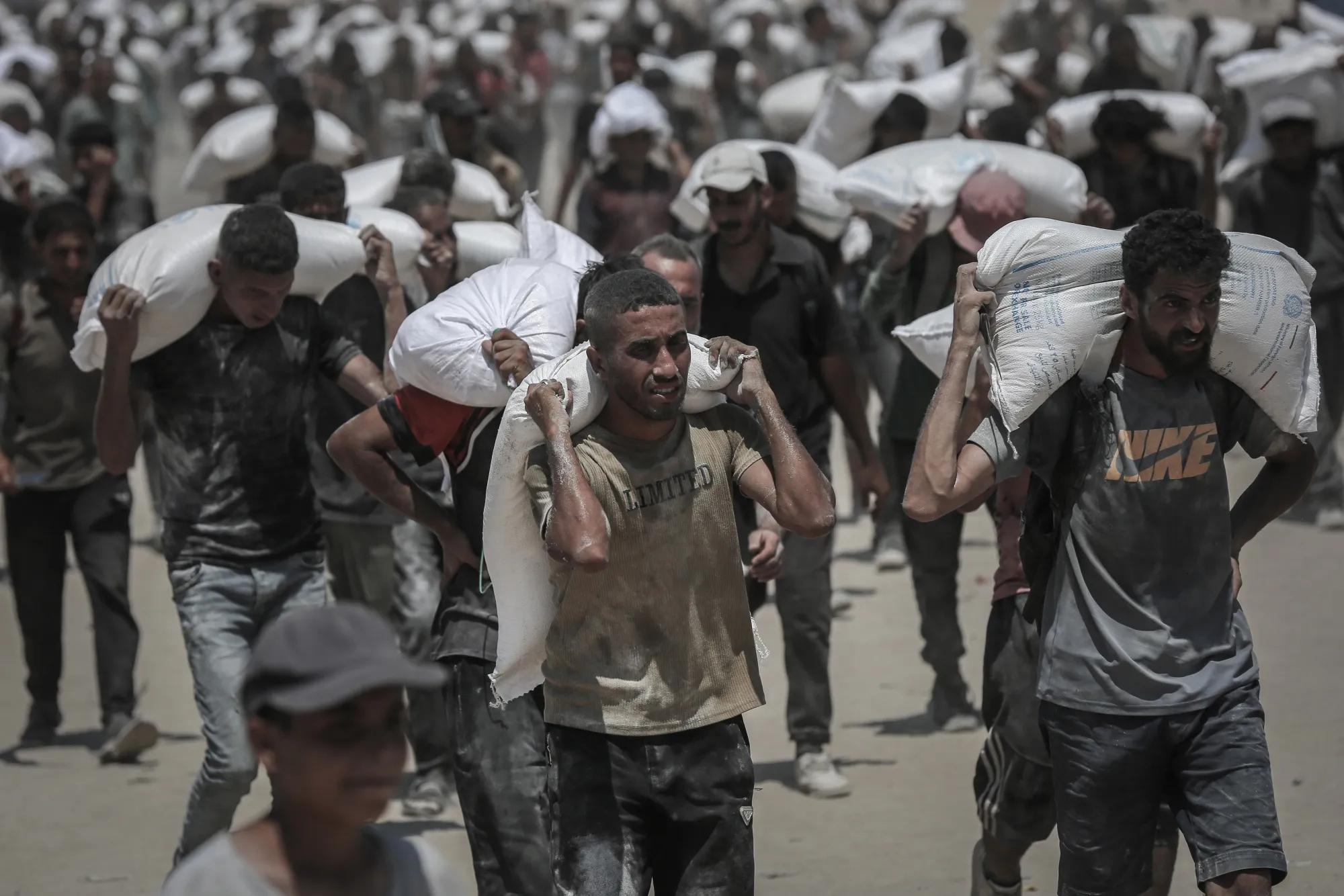 Palestinians carry aid supplies in Beit Lahia, northern Gaza, on July 27.