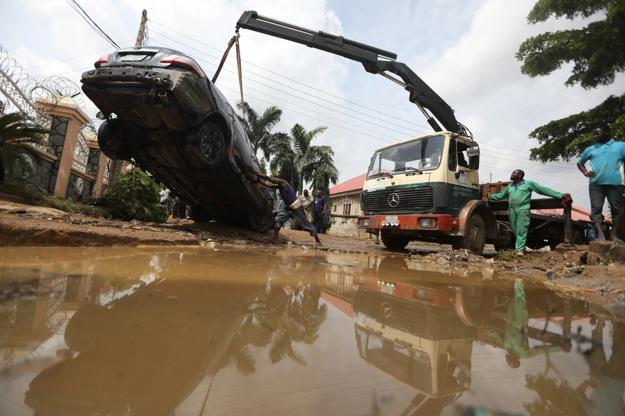 People attempt to pull out a car washed away by flood water in&nbsp;Lugbe, Nigeria.&nbsp;