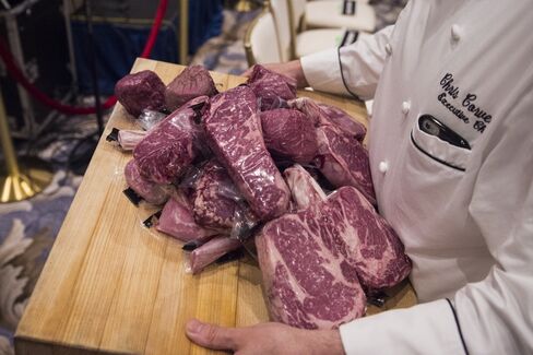 A worker carries steaks back to the kitchen before republican presidential candidate Donald Trump is expected to speak at a campaign press conference event at the Trump National Golf Club in Jupiter, Fla. on March 8, 2016.