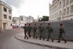 Several soldiers walk in formation while carrying a Cuban flag through the streets of downtown Havana, Cuba. Havana, Cuba