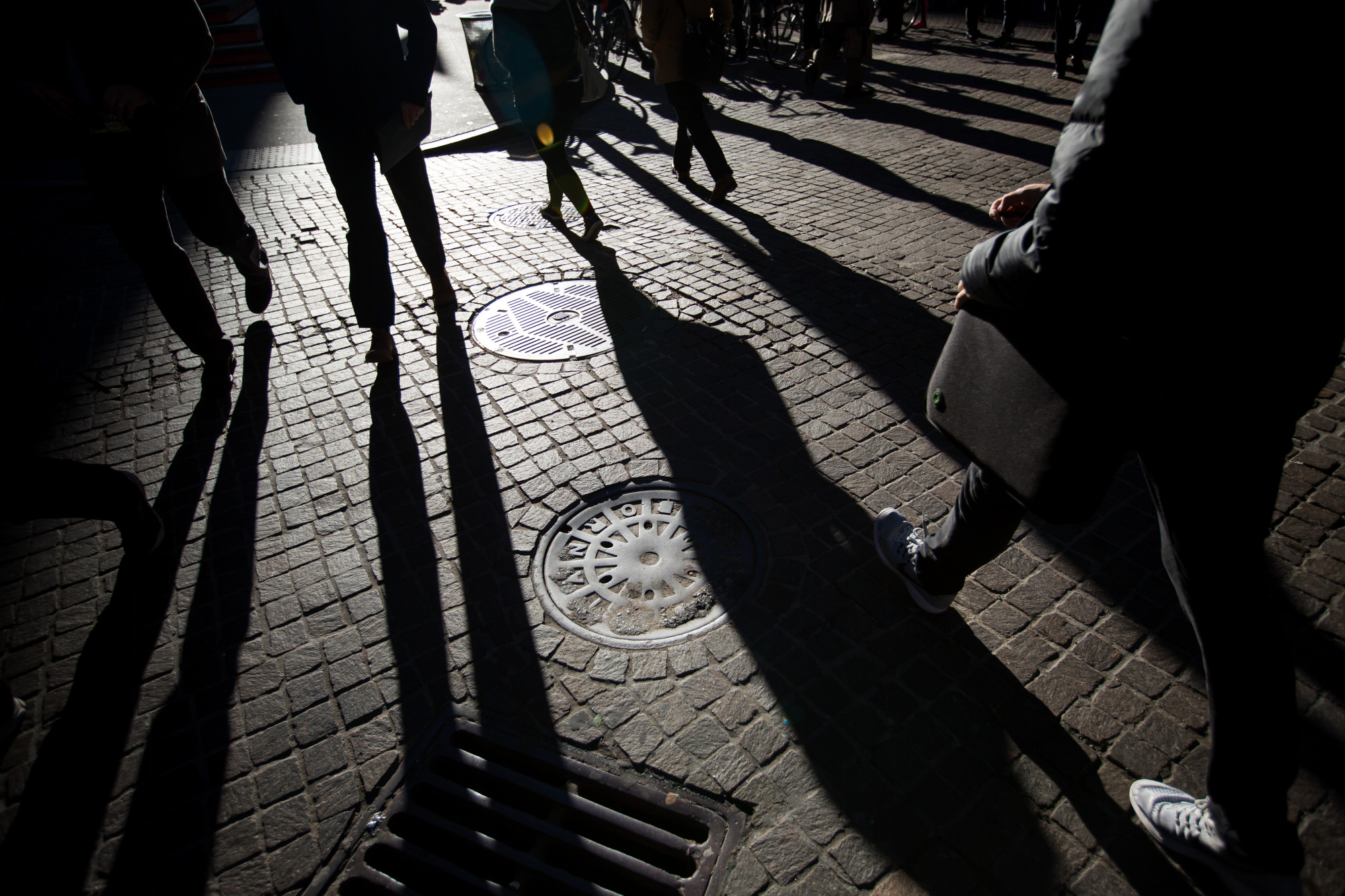 Pedestrians walk along Wall Street near the New York Stock Exchange (NYSE) in New York, U.S.