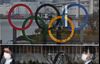 The Olympic Rings are reflected in a glass panel at Odaiba Seaside Park in Tokyo on March 8, 2020.