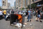 Demonstrators set an upturned garbage can alight as part of a road block during an anti-government protest in Beirut on July 1.