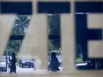 Employees are reflected in a ZTE Corp. sign at the company's headquarters in the Nanshan district of Shenzhen.