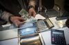 An employee counts out U.S. dollar banknotes at a currency exchange store on Ferdowsi street in Tehran, Iran, on Saturday, Jan. 6, 2018. A wave of bad loans from unregulated lenders has rocked the banking sector and oil prices have averaged less than $60 a barrel for the past three years, draining Iran of a key source of revenue.