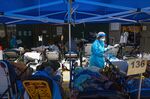 A healthcare worker attends to patients at a temporary triage area at the Caritas Medical Center hospital in Hong Kong.