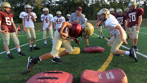 CONCORD, MA - AUGUST 16: Kevin Smith, President of Concord-Carlisle Pop Warner Football, center, coaches a one-on-one drill during practice.
