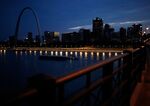 A river barge passes the St. Louis Gateway Arch along the Mississippi River in St. Louis, Missouri.