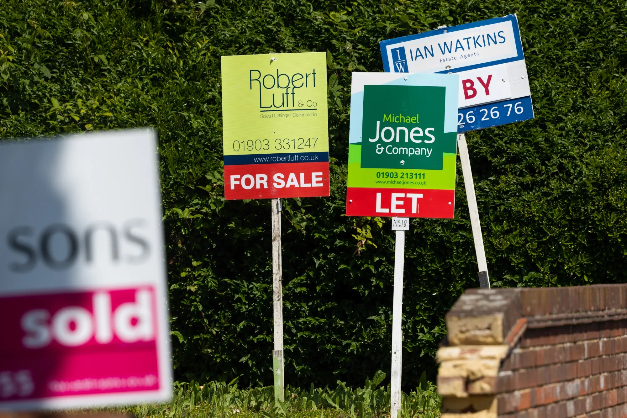 Estate agents' signs outside a residential apartment block.