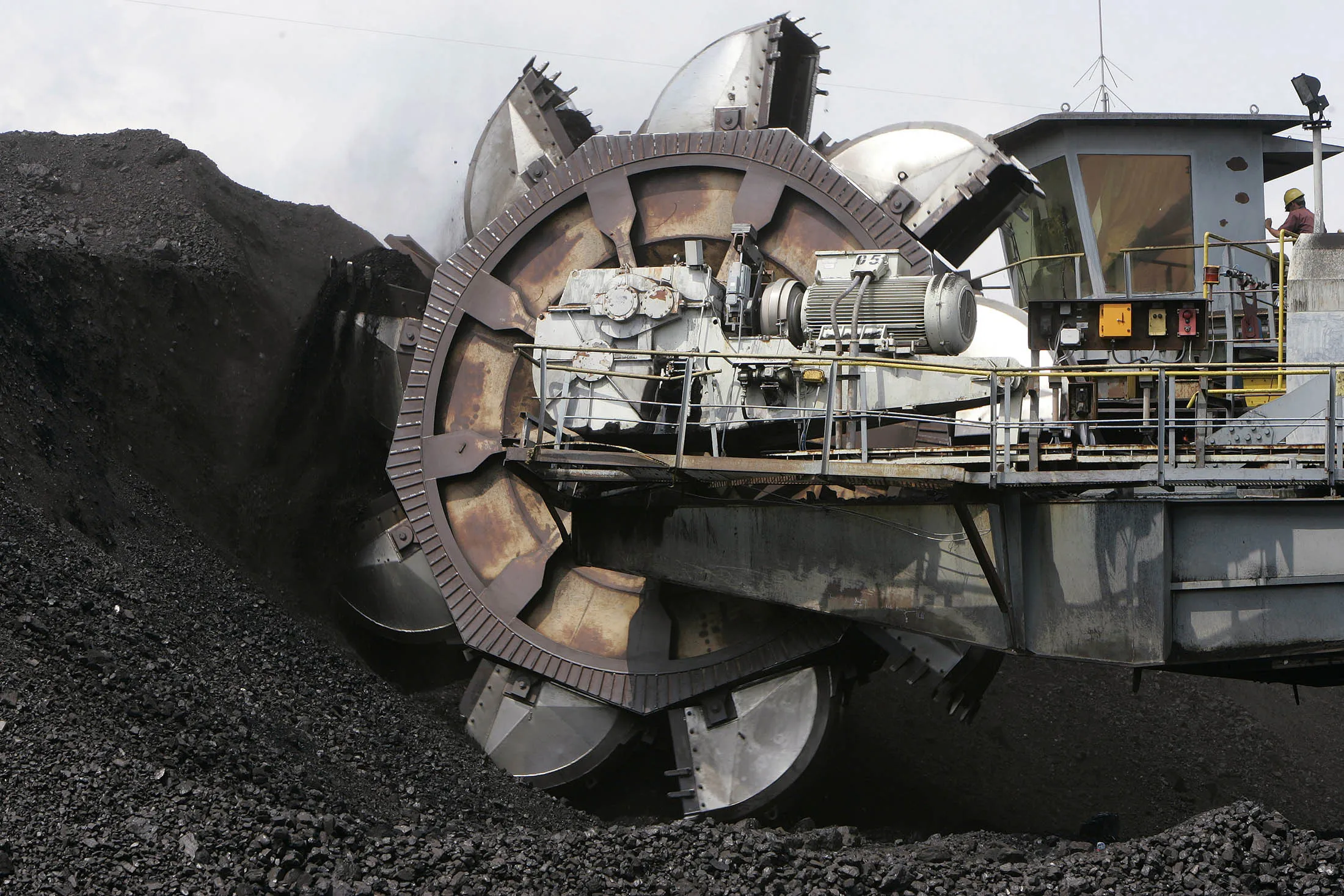 A bucket wheel excavator loads coal onto a conveyor belt in Indonesia
