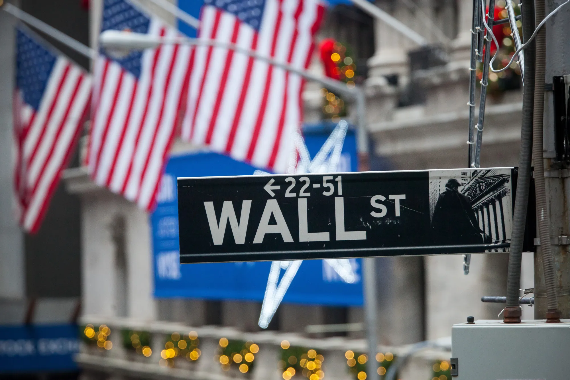 A Wall Street sign is seen in front of the New York Stock Exchange (NYSE) in New York, U.S., on Monday, Dec. 18, 2017.
