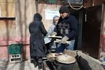 People cook a meal in the rubble of an apartment damaged by shelling in Mariupol on March 29.
