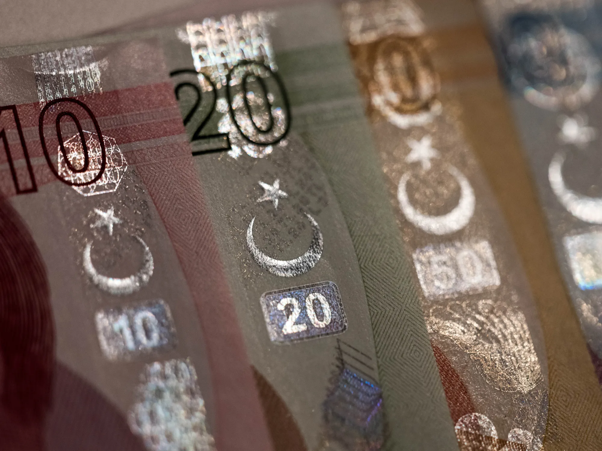 Star and Cresent symbols sit on an assortment of Turkish Lira banknotes in this arranged photograph in London, U.K., on Wednesday, Aug. 15, 2018. Turkey took its boldest steps yet to try to ward off a financial crisis by making it harder for traders to bet against the battered lira and easing rules on restructuring troubled loans that have already topped $20 billion.