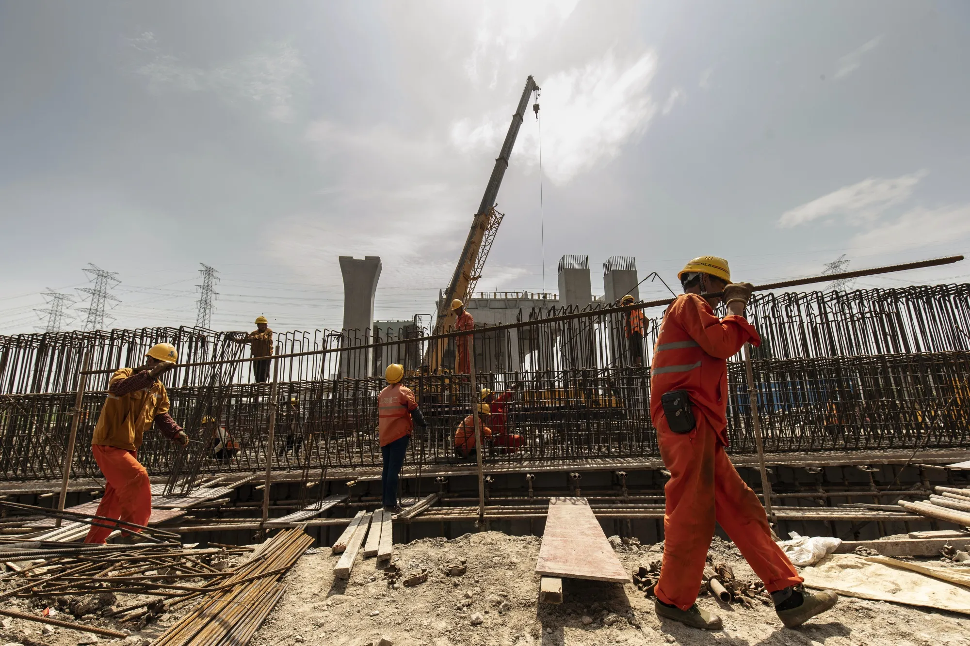 Workers carry a steel bar at the construction site on the outskirts of Shanghai on June 12.