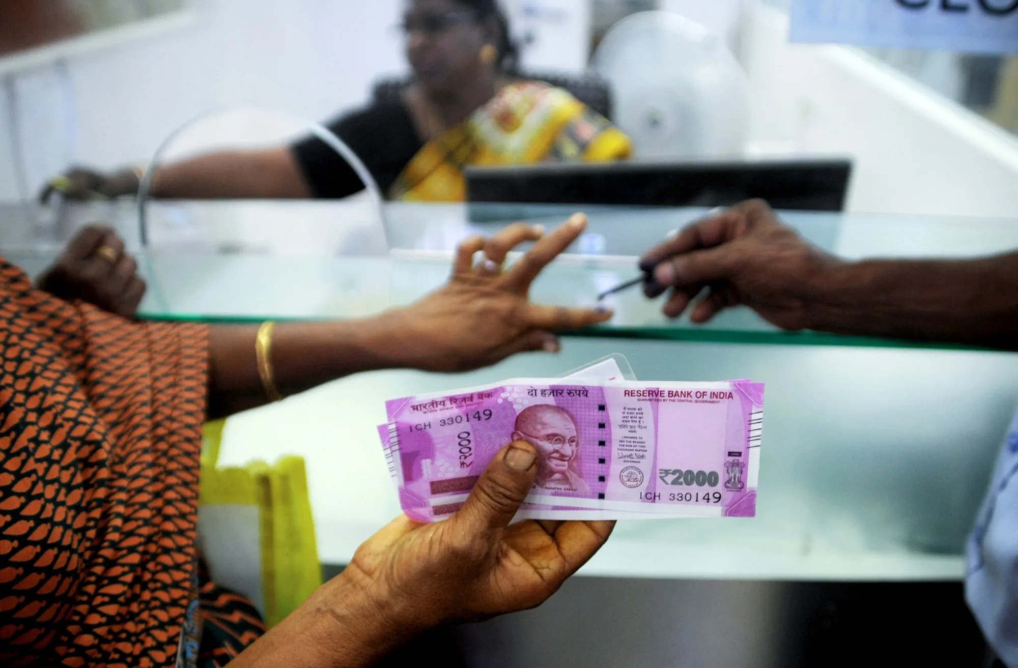 A&nbsp;woman displays her 2000 rupee notes for exchange.