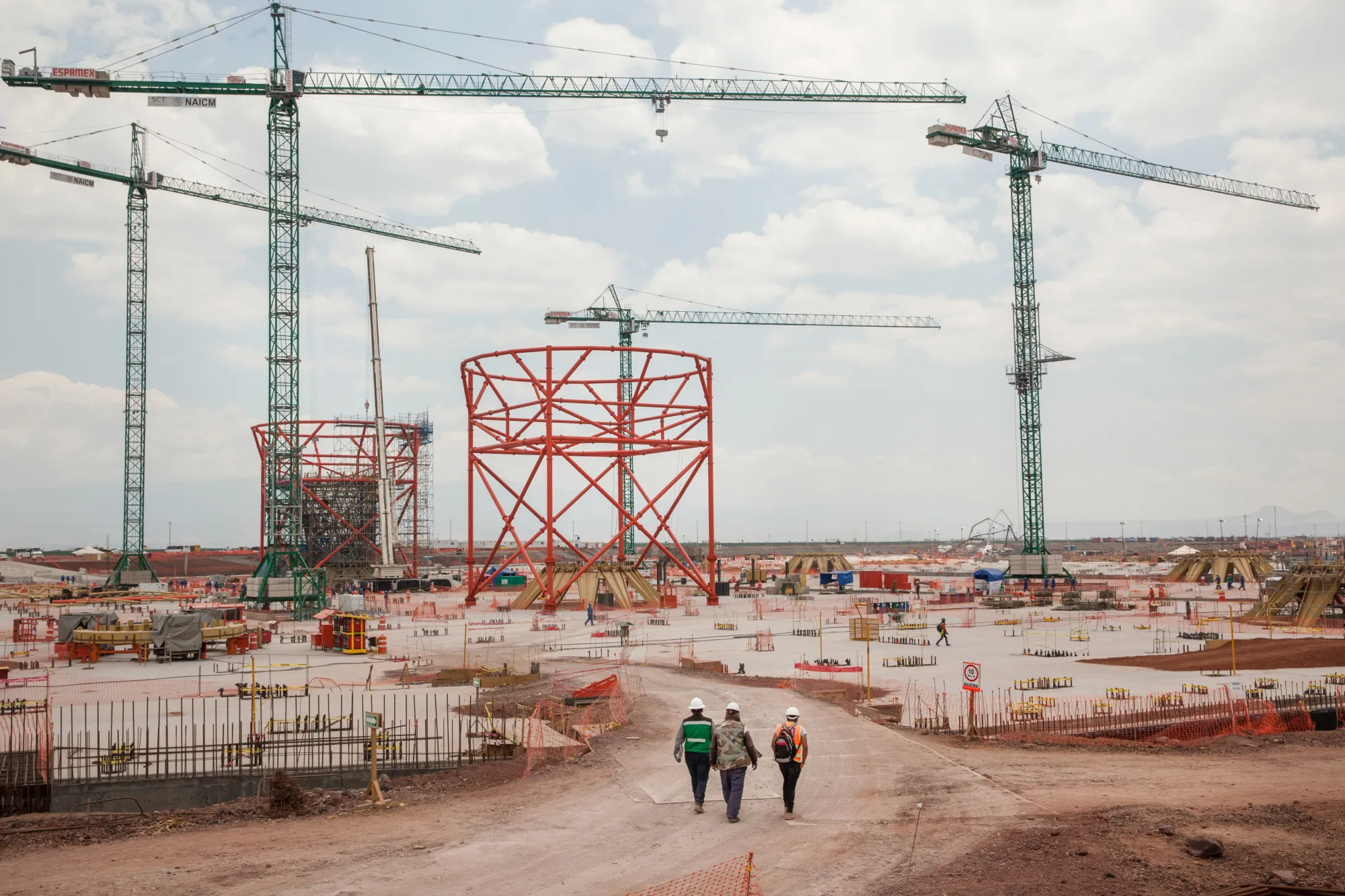 Workers pass in front of a terminal under construction at the New International Airport of Mexico City in Texcoco, Mexico, on April 13, 2018.