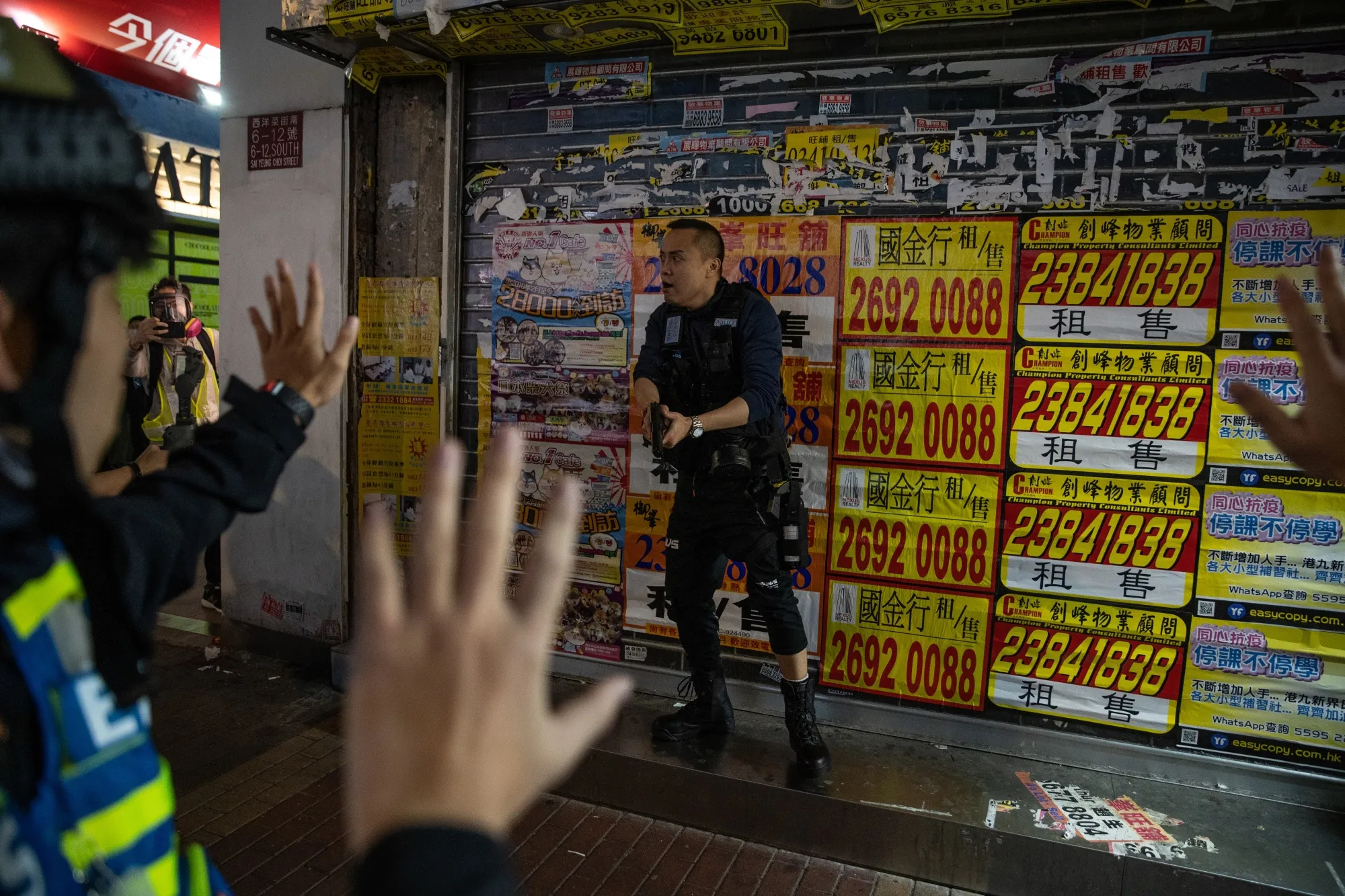 A police officer draws a weapon during a protest in the Mong Kok district of Hong Kong&nbsp;on&nbsp;Feb. 29.
