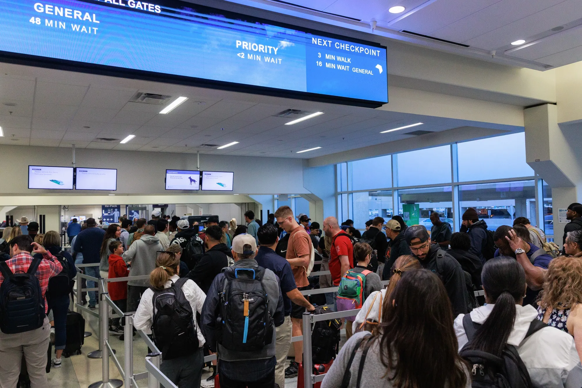 Travelers wait in line at a security checkpoint at Dallas-Fort Worth International Airport on Oct. 20, 2025.