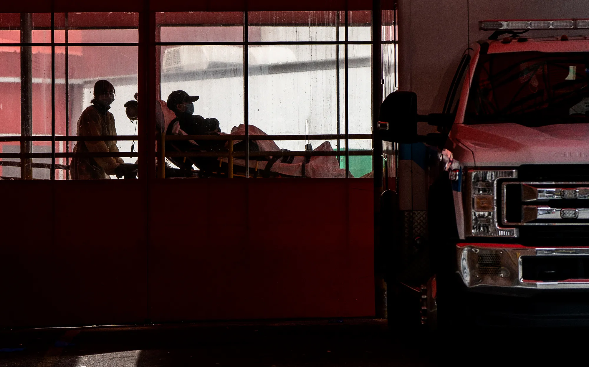 EMTs wearing protective equipment carry a patient into a hospital&nbsp;in the Queens borough of New York.