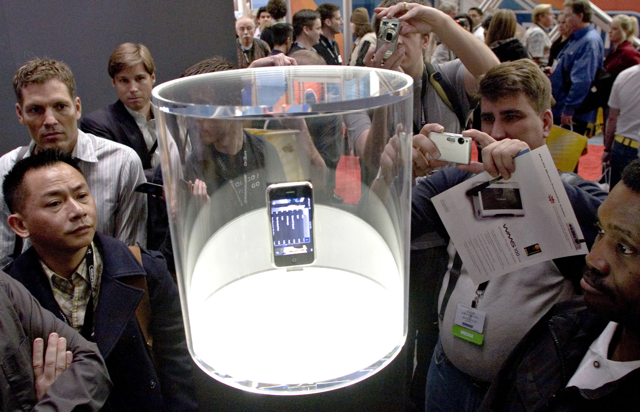 MacWorld attendees look over an iPhone on display during MacWorld in San Francisco on Jan. 9, 2007.