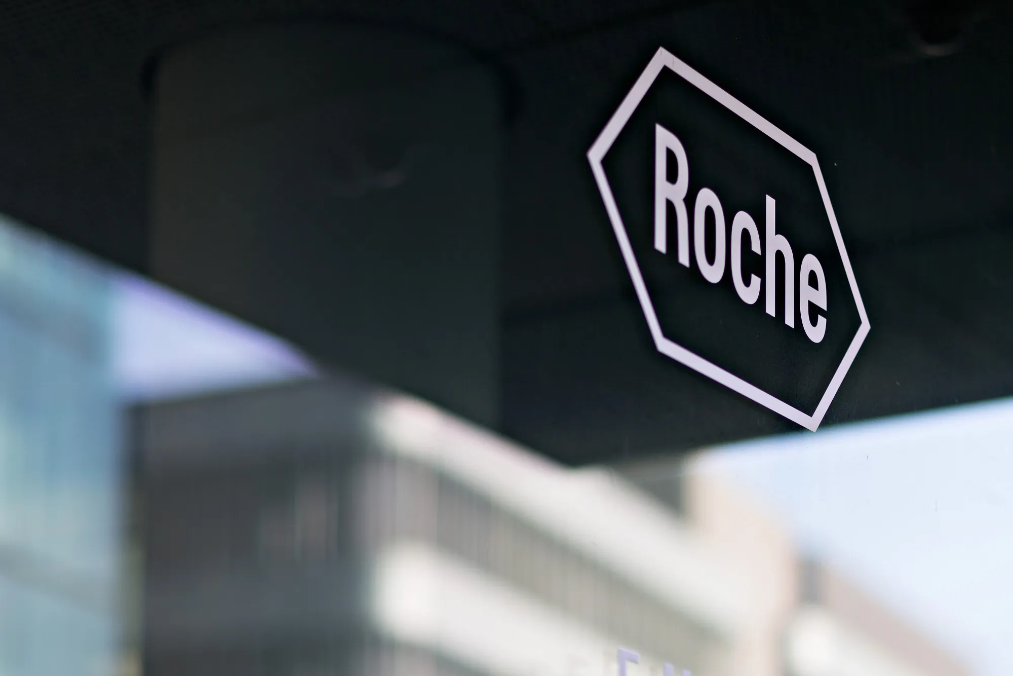 The company logo for Roche Holding AG is seen on a glass doorway at the company's headquarters in Basel, Switzerland, on Wednesday, Feb. 1, 2017. Roche Holding AG is bracing for slower earnings growth this year as its ageing cancer blockbusters face competition and the Swiss drugmaker readies a new generation of medicines.