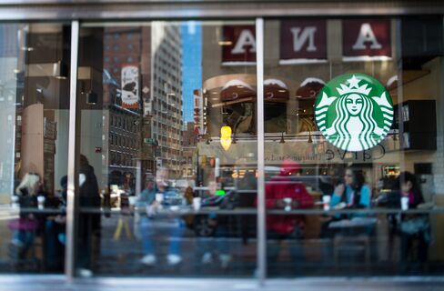 Customers Sit inside a Starbucks Coffee Shop in New York