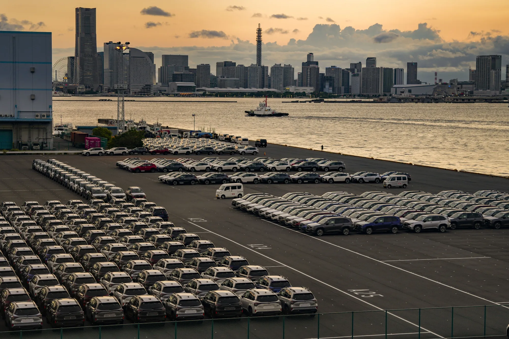 Vehicles bound for shipment at a port at dusk in Yokohama.