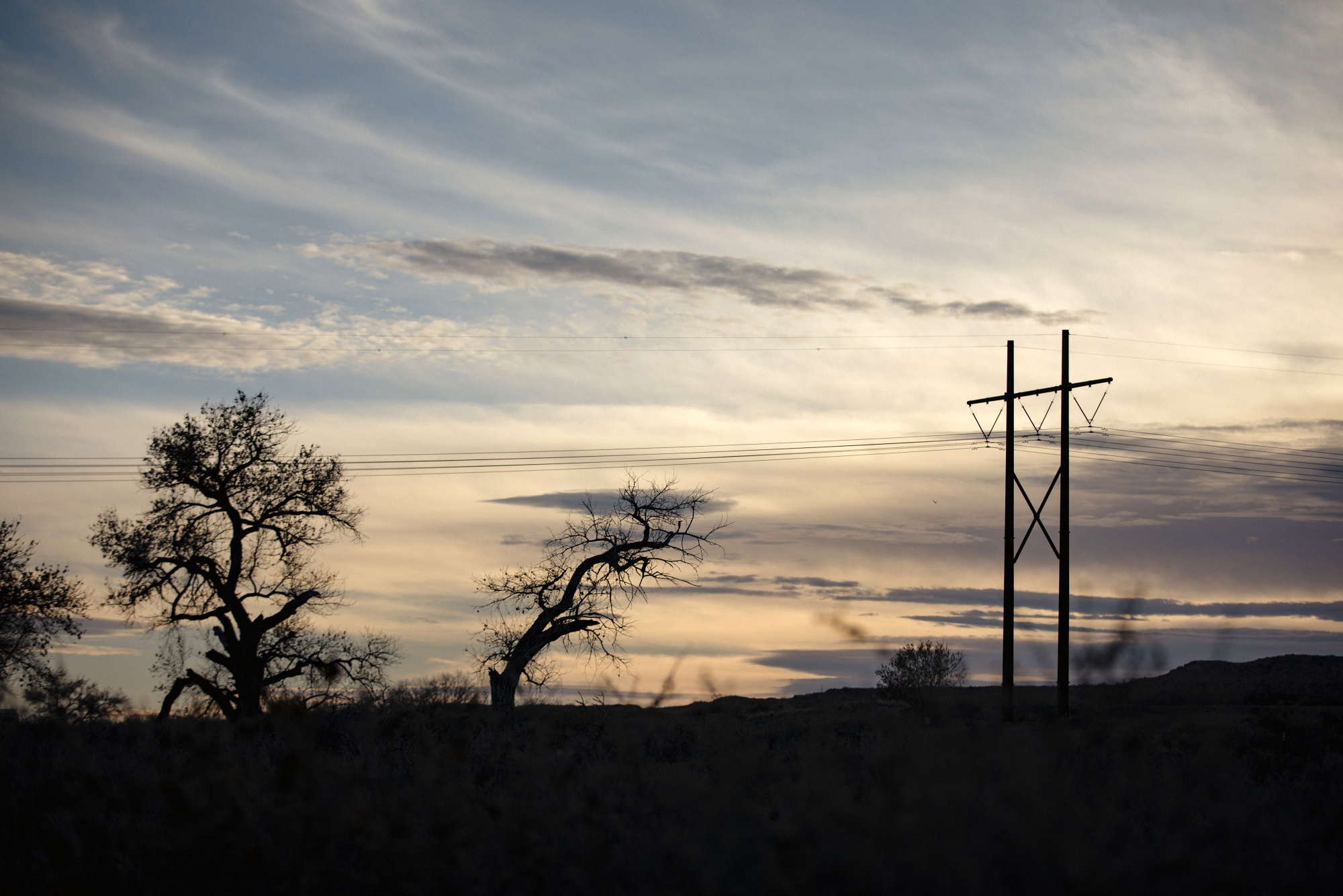 Western Spirit transmission lines tower above the interstate and farmlands in Bosque, NM on January 14, 2023.
