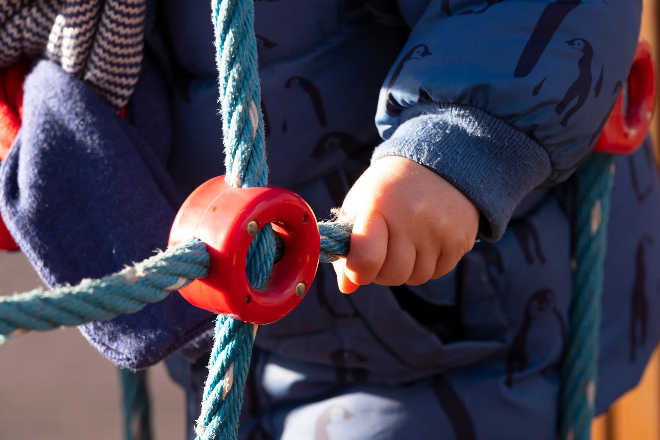 detail of the hand of a child playing in a playground