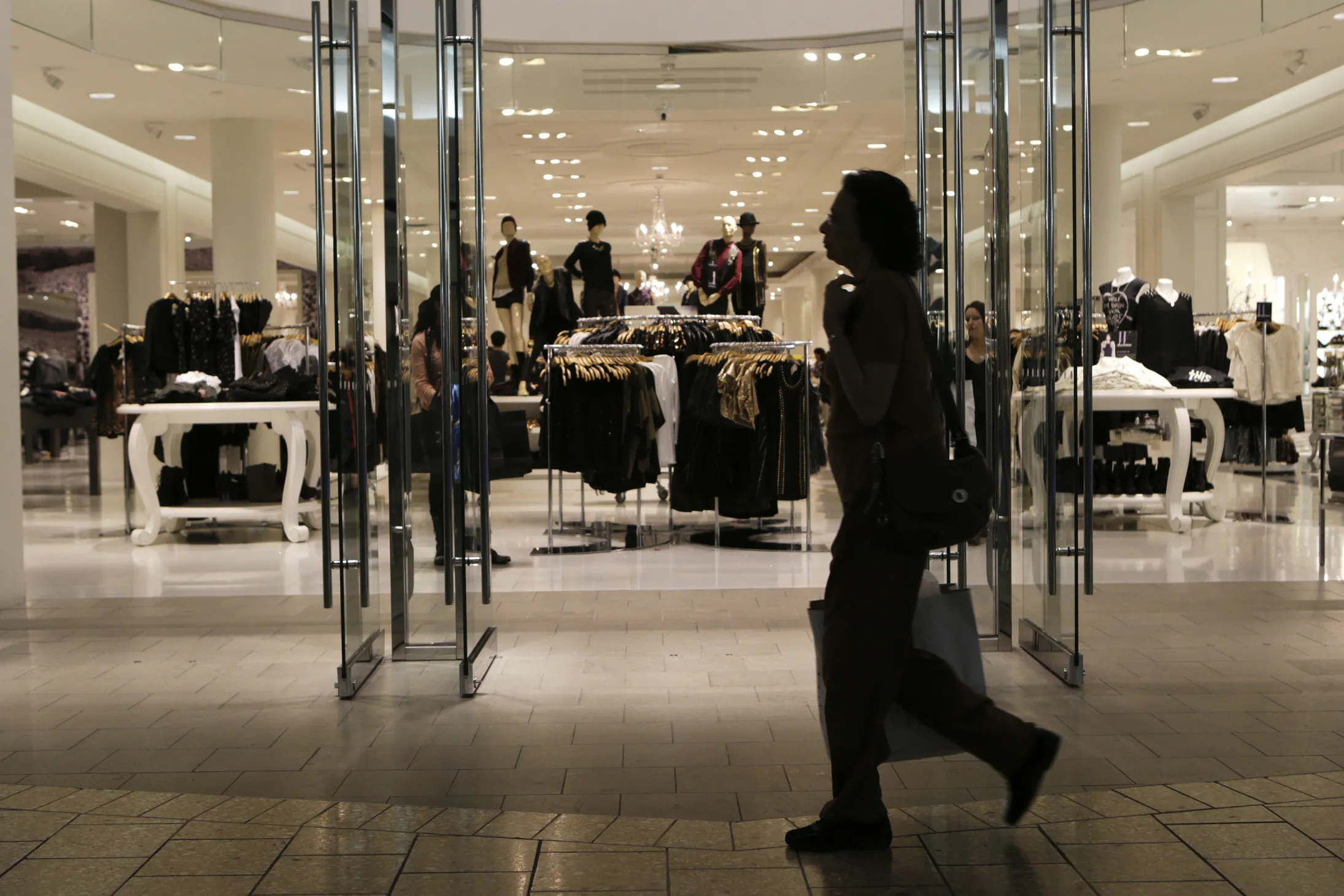 A woman carries a shopping bag while walking past a Forever 21&nbsp;store at the Fair Oaks Mall in Fairfax, Virginia.