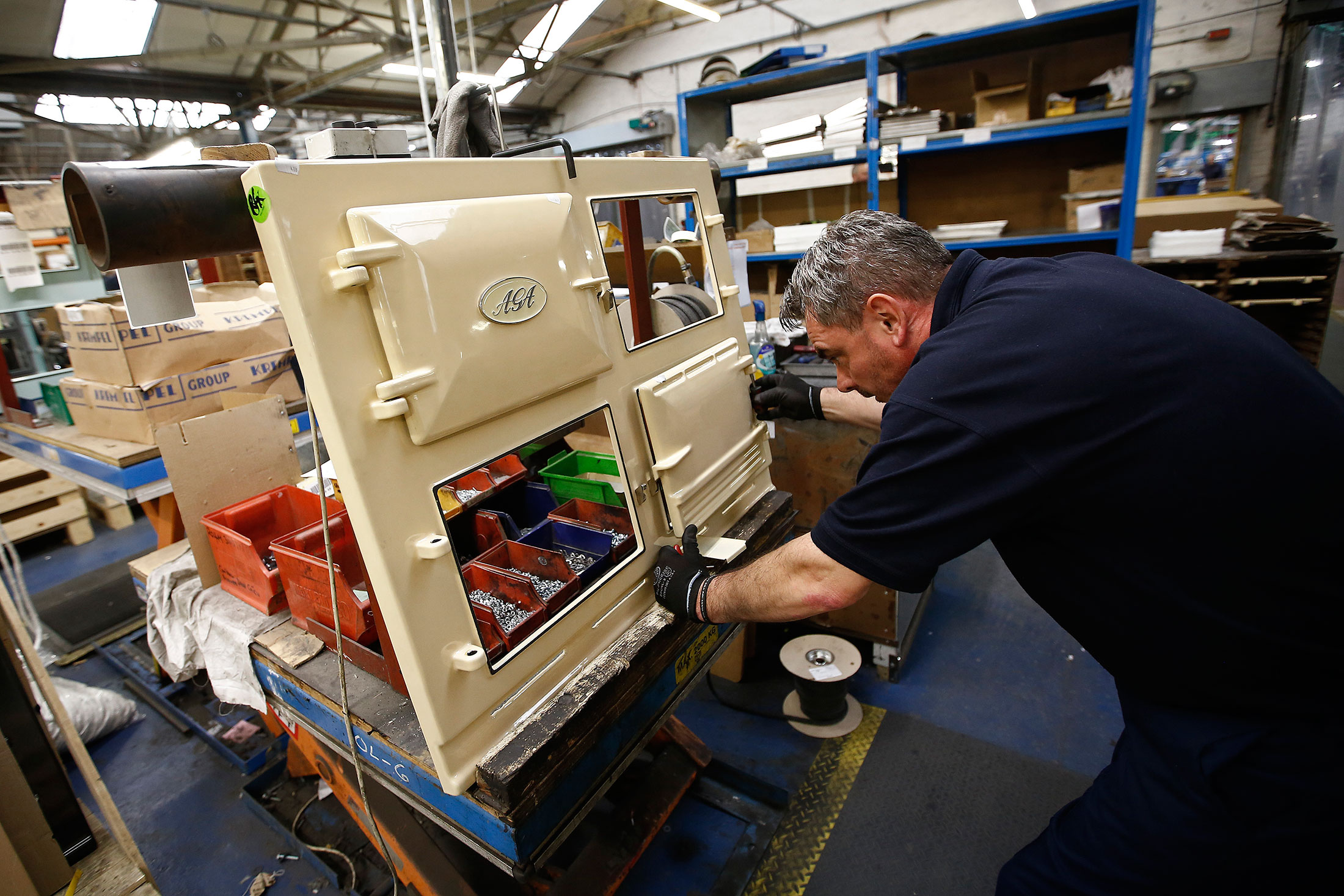 An employee fits a door to an AGA 3-Oven Classic range cooker at the company's plant in Telford, U.K.
