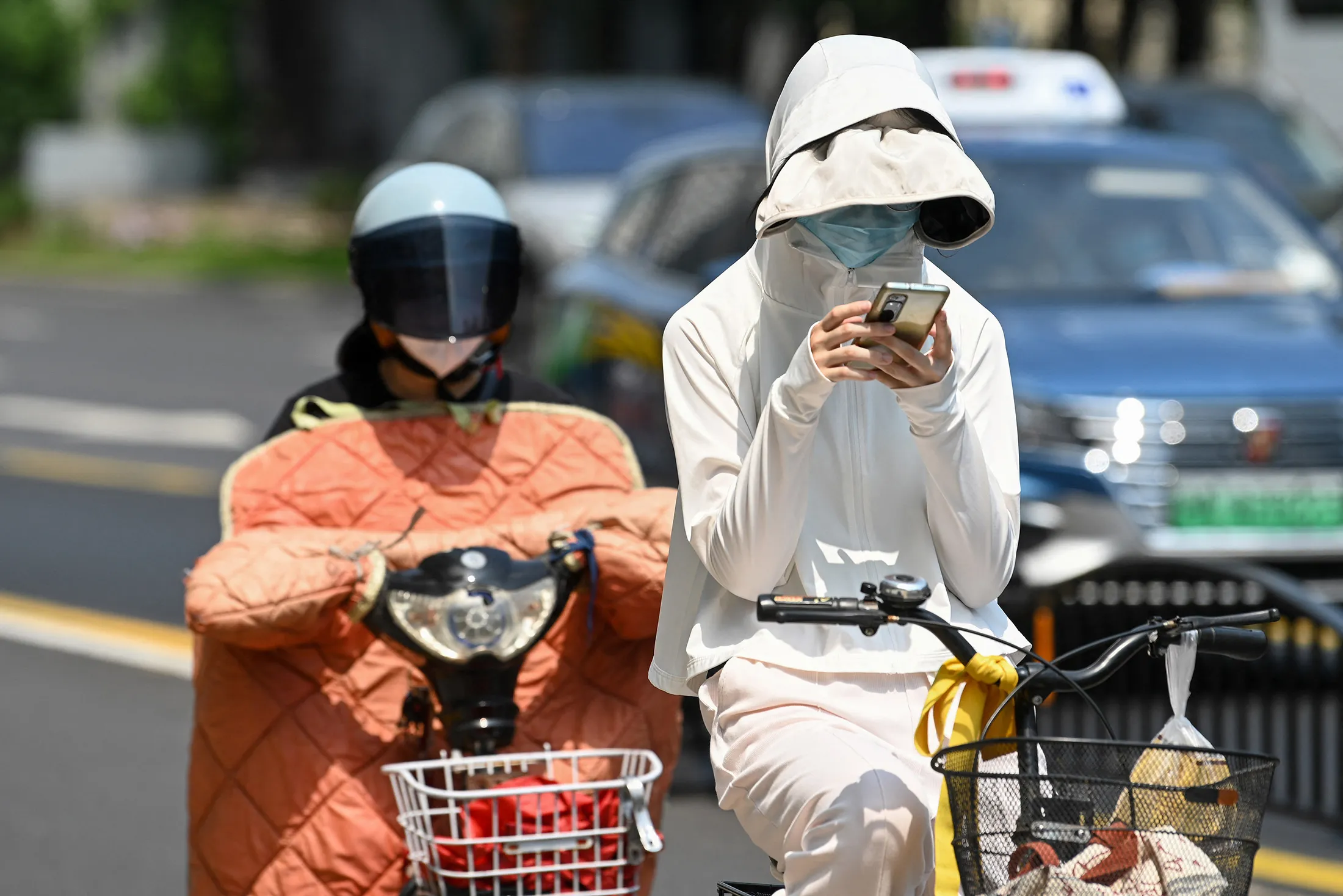 A cyclist wears sun protective clothing amid hot weather in Shanghai on May 29.