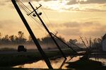 Downed power lines slump over a road in the aftermath of Hurricane Ida, Friday, Sept. 3, 2021, in Reserve, La. Weather disasters fueled by climate change now roll across the U.S. year-round, battering the nation's aging electric grid. (AP Photo/Matt Slocum, File)