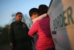 A child from El Salvador clings to his mother after she turned themselves in to U.S. Border Patrol near Rio Grande City, Texas.