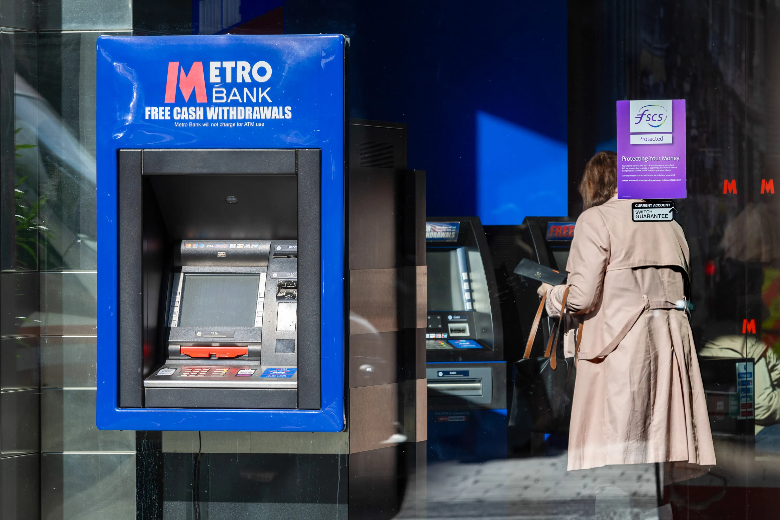 A customer uses an ATM at a Metro Bank&nbsp;branch in London, UK.