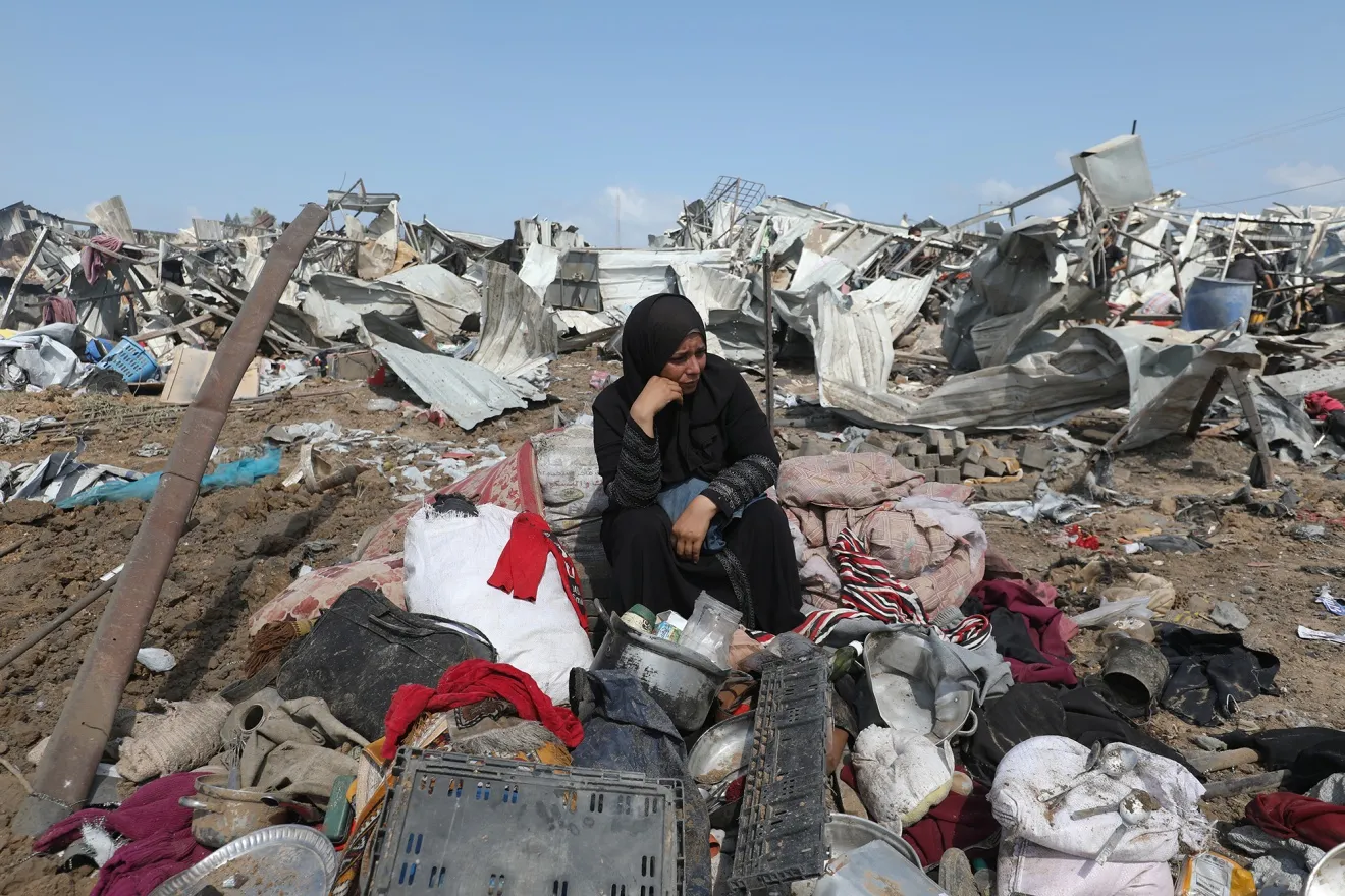 A displaced woman sits with her belongings after an Israeli strike in Deir el-Balah, Gaza on Aug. 21