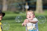 A child in London chases bubbles in a sunny spring day