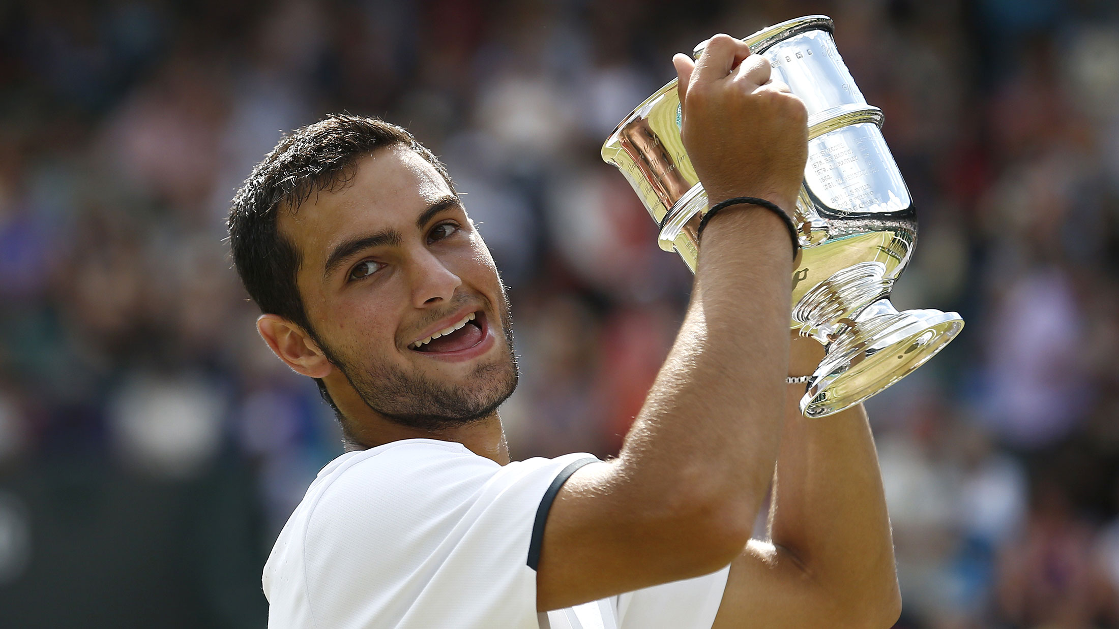 Noah Rubin raises his trophy after winning the boys’ singles final match at Wimbledon last year.
