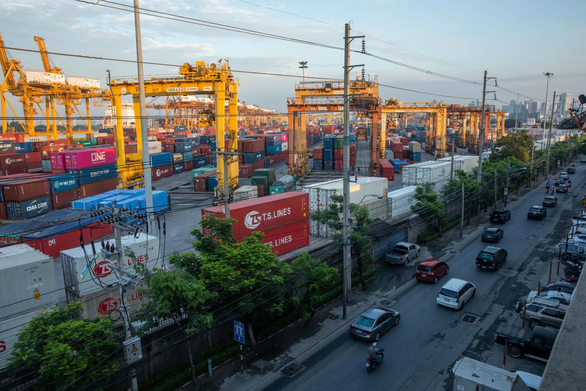 Vehicles travel past shipping containers and gantry cranes at the Bangkok Port in Bangkok, Thailand, on Wednesday, Sept. 2, 2020.