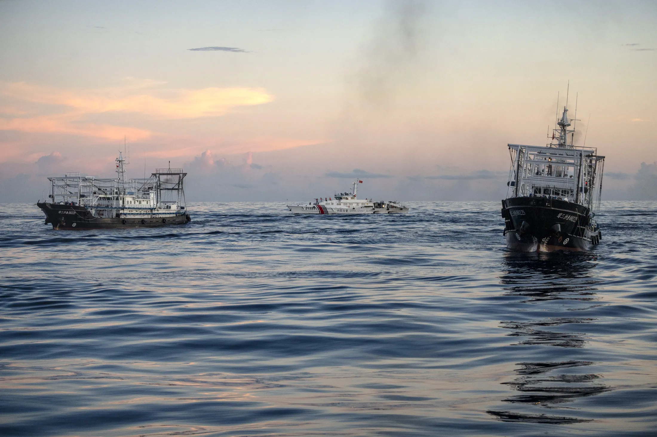 A China Coast Guard vessel&nbsp;and Chinese fishing trawlers during a resupply mission to the BRP Sierra Madre in the South China Sea on Nov. 10.