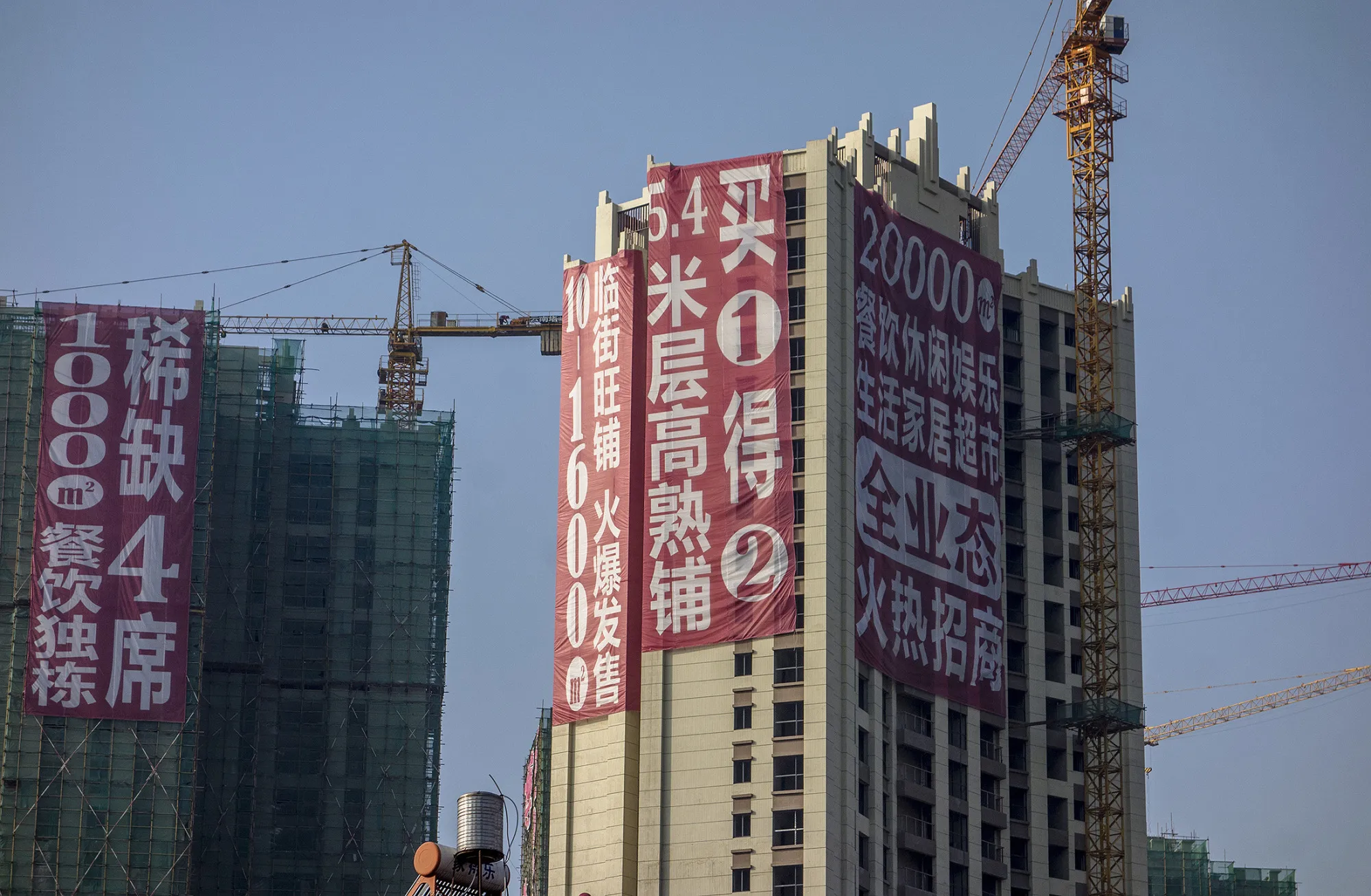 KUNMING, YUNNAN PROVINCE, CHINA - 2015/12/14: Huge promotion advertisement hangs on a real estate project under construction. The ratio of supply to demand in Kunming is 2.39 and the new house vacancy rate is over 70%. In 2016, Chinese government will take more steps to tackle the high real estate inventories.
