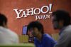 Yahoo Japan Corp. employees speak to their customer in front of the company's logo at its headquarters in Tokyo, Japan,