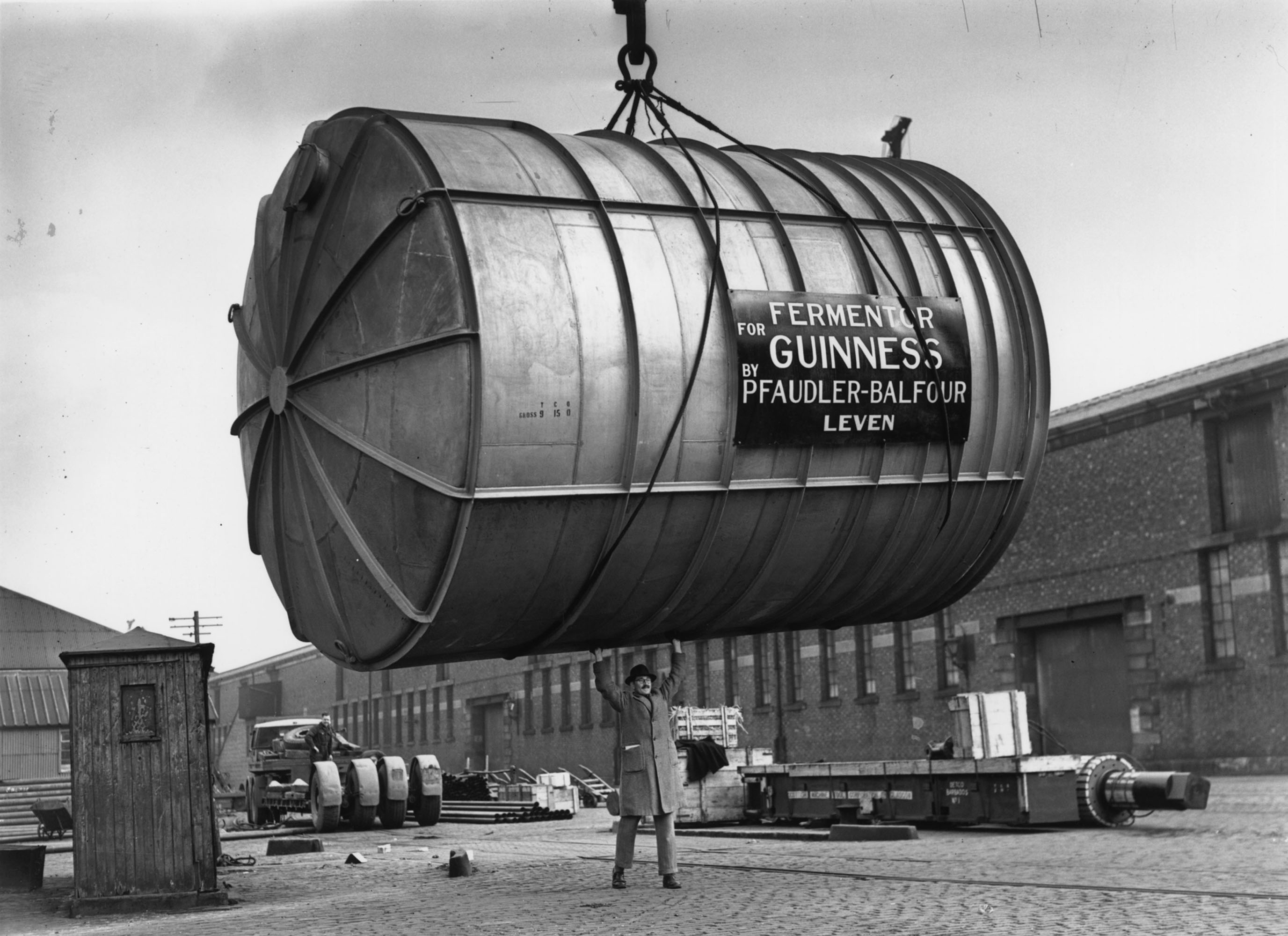A man guides a 10-ton stainless steel fermenting tun, constructed in Glasgow onto a ship en route to the Guinness Brewery in Dublin, 1949.