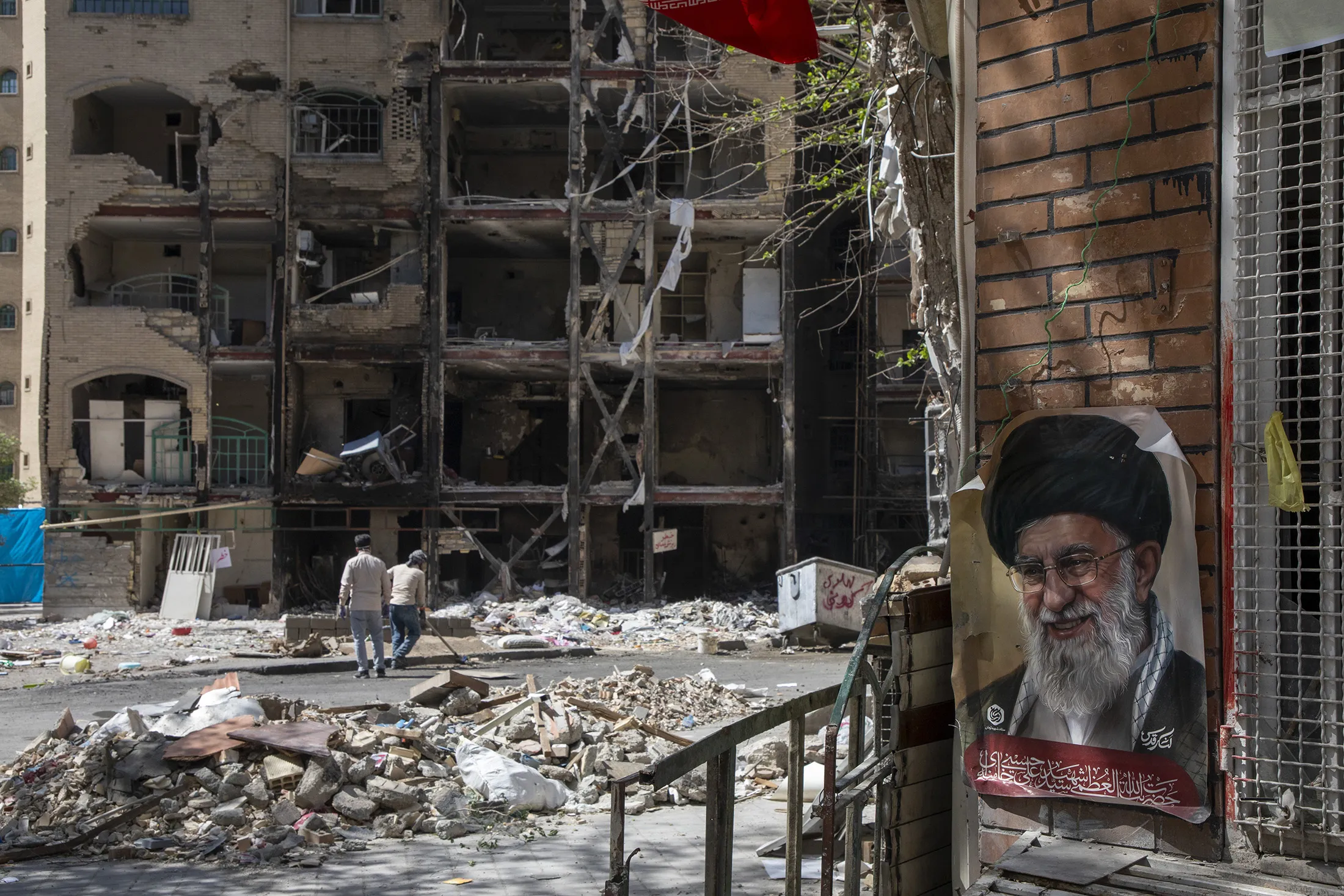 Men walk past a damaged residential building in Tehran, Iran,&nbsp;on April 14.